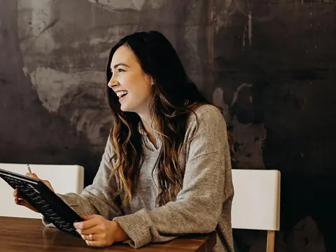 A café manager smiling while working on a tablet